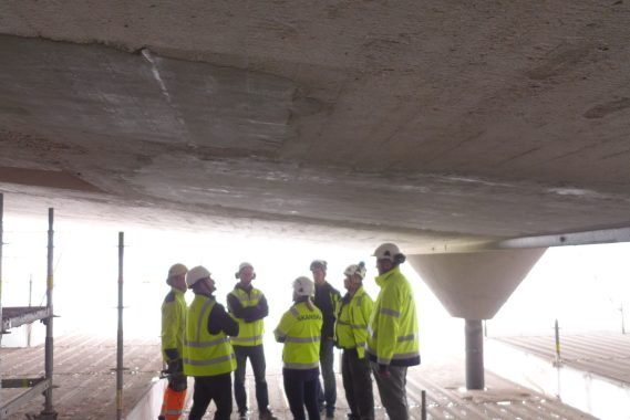 Suunnittelijoita ja toteuttajia katselmoimassa pääkatsomon vanhan katoksen betonikorjauksen mallityötä